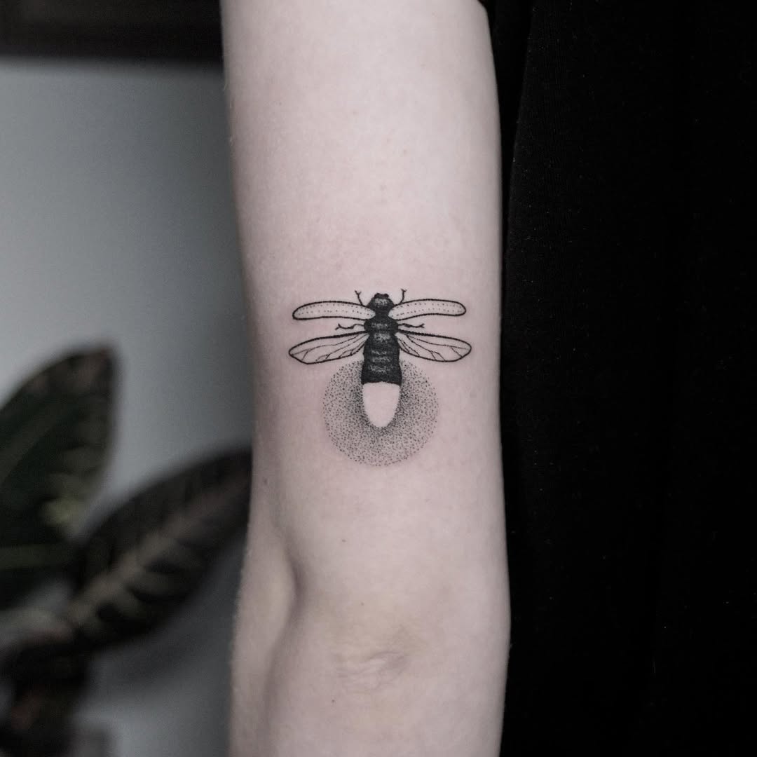 Stunning black line firefly tattoo on arm