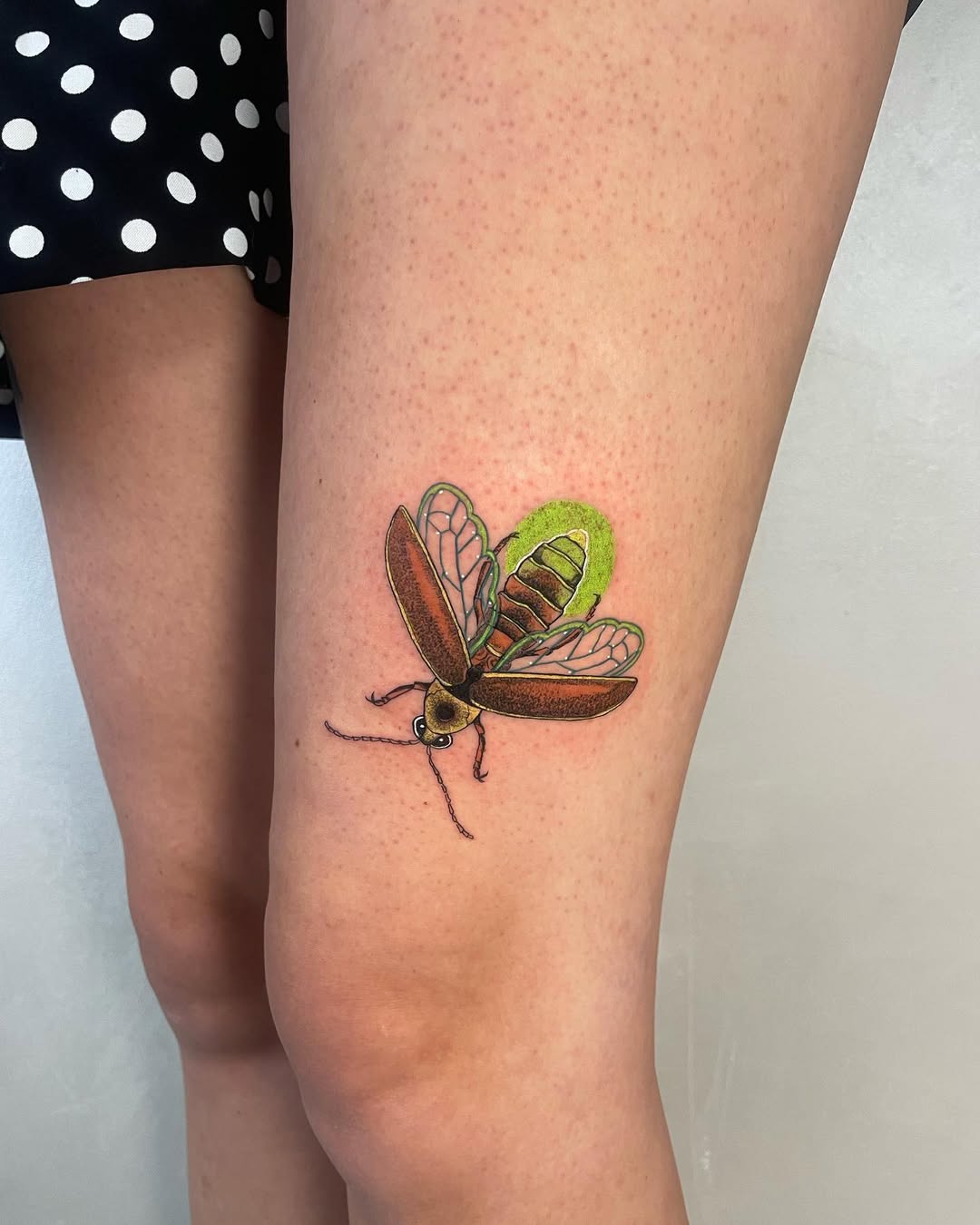 Vibrant firefly tattoo radiating whimsical charm