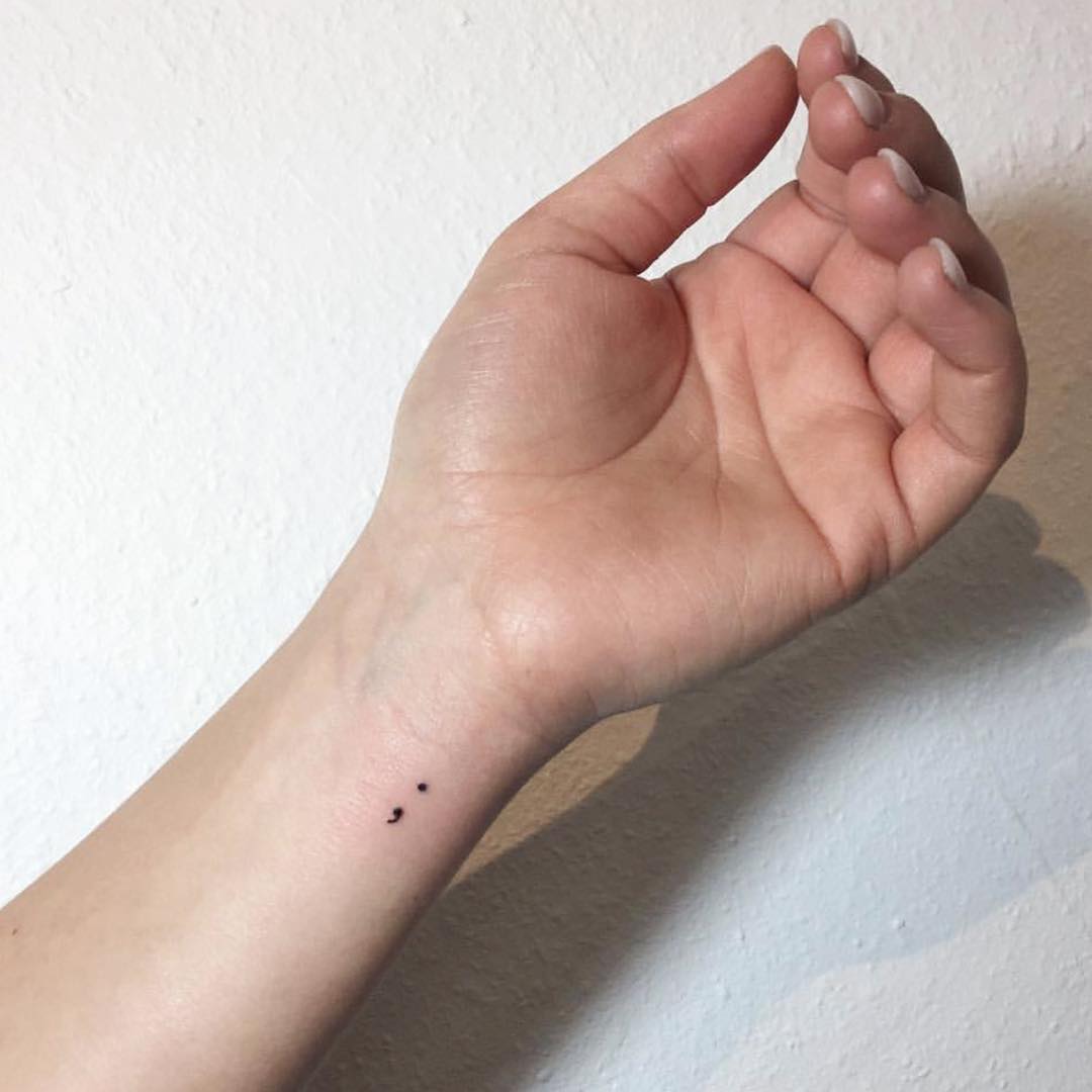 Minimalistic semicolon tattoo on the wrist