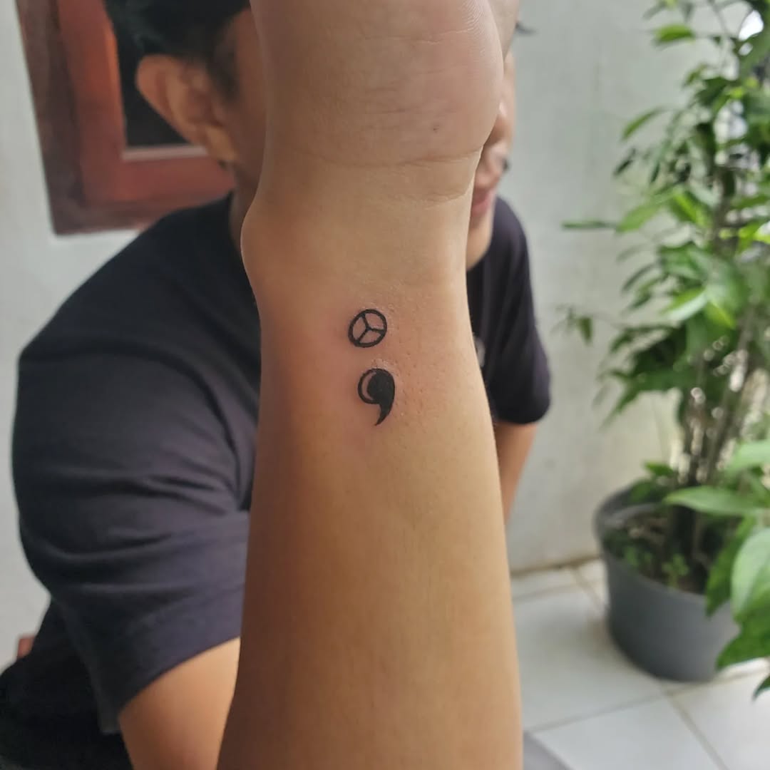 Stylish minimalist semicolon tattoo on forearm