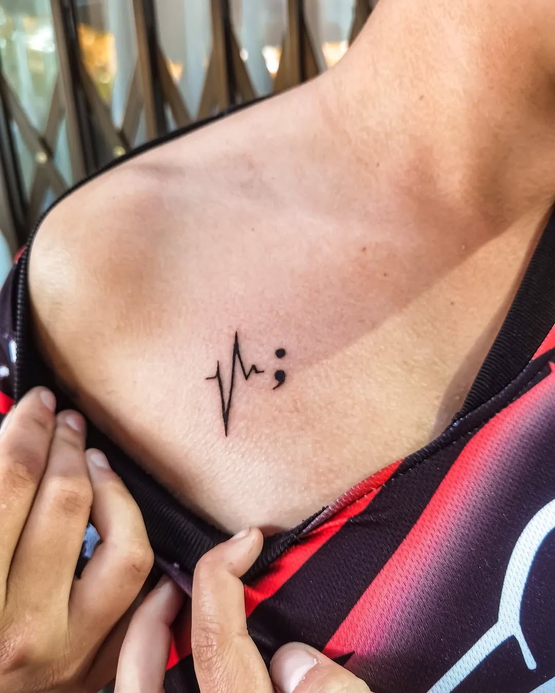 Meaningful semicolon heartbeat tattoo on display