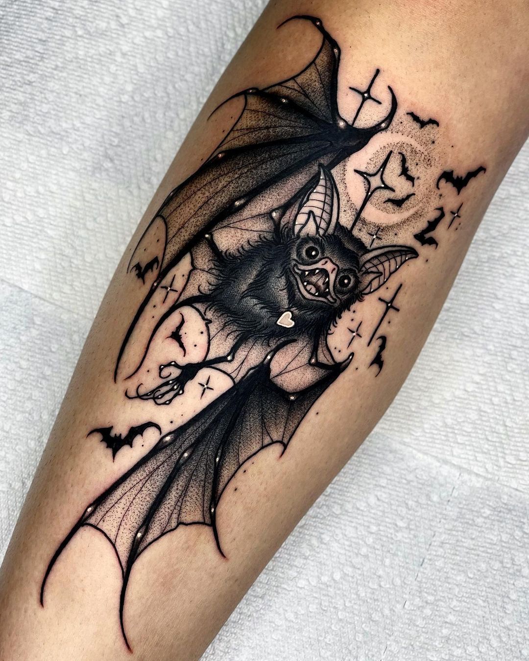 A whimsical bat tattoo with bold blackwork style