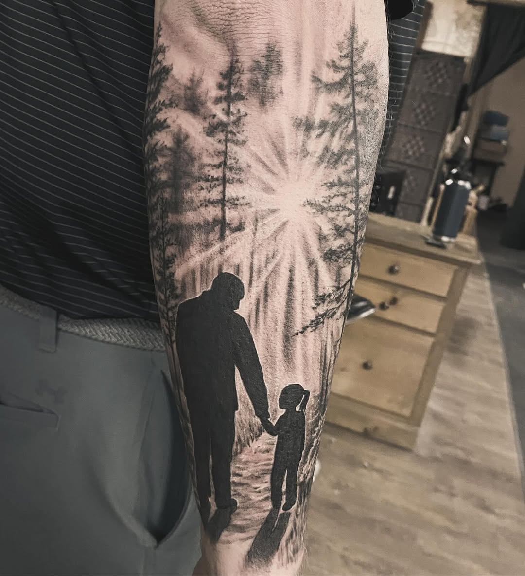 Heartwarming father-daughter silhouette tattoo design