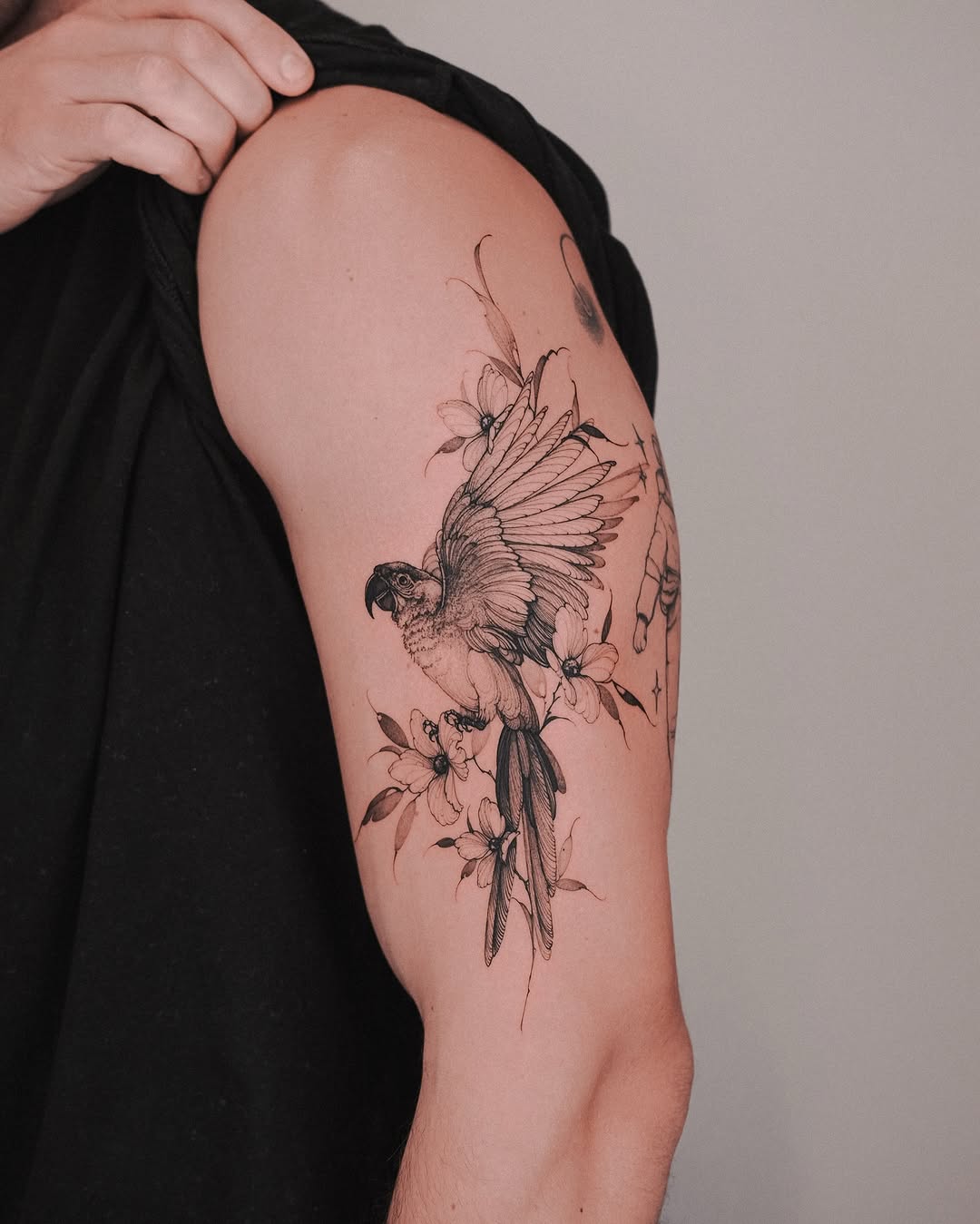 Intricate parrot tattoo with floral accents