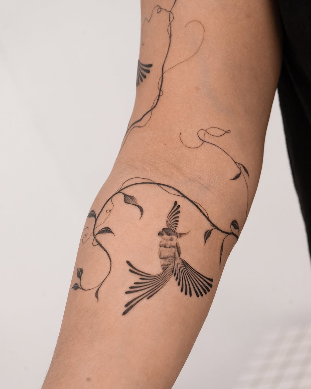 Stylish parrot tattoo with vine accents