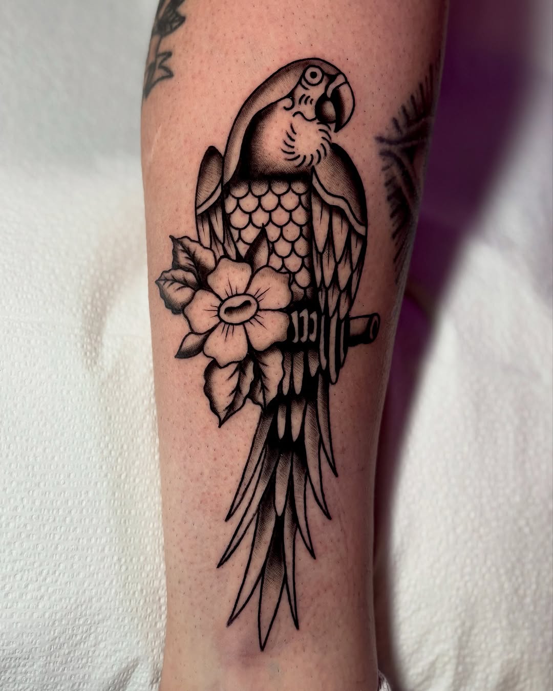 Stylish parrot tattoo with floral details