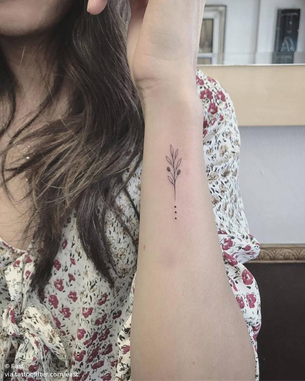 Single needle olive branch tattoo on the wrist.
