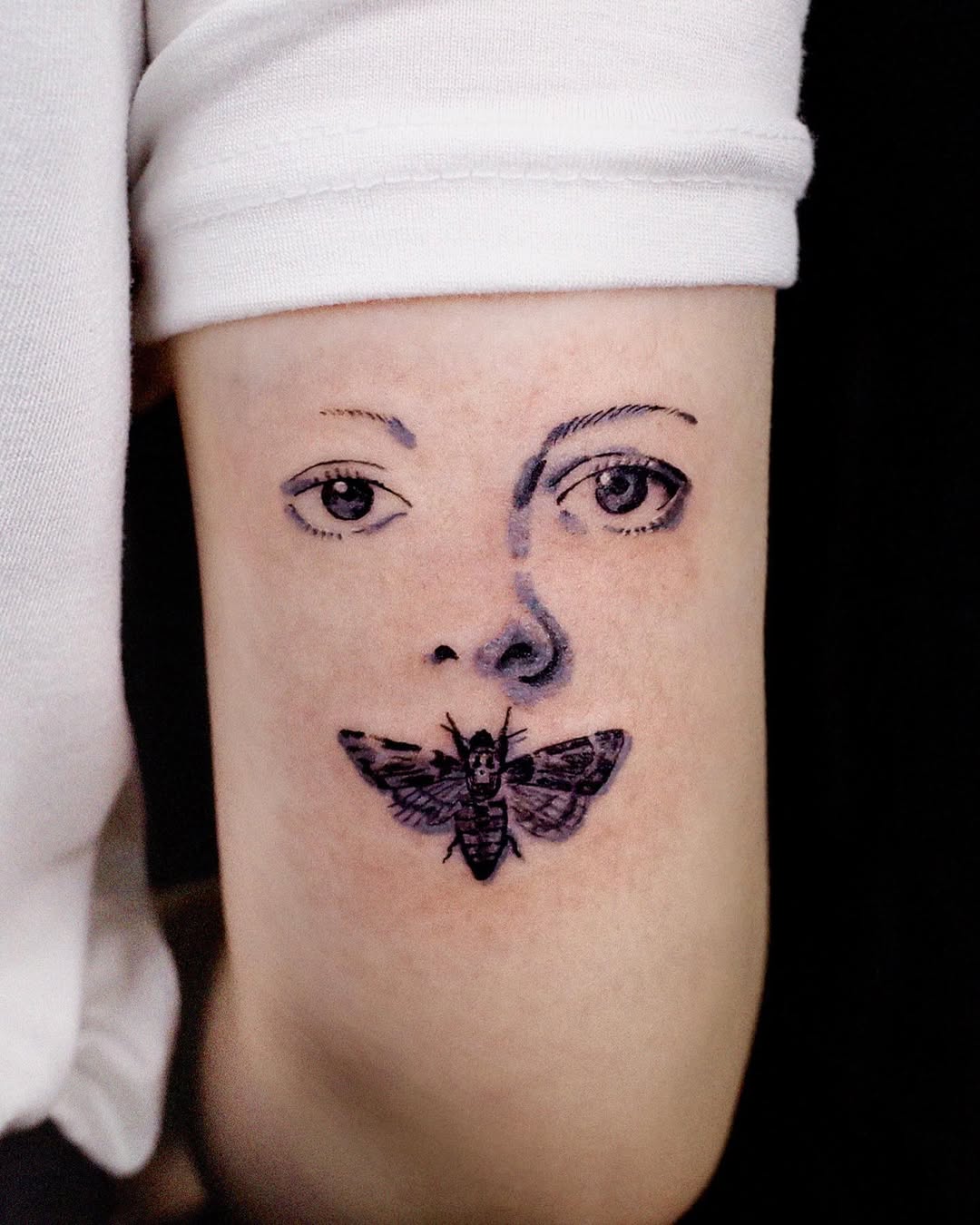 Intricate tattoo of a face and butterfly