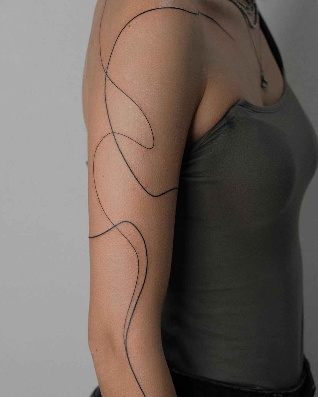 Elegant black line tattoo for stylish women