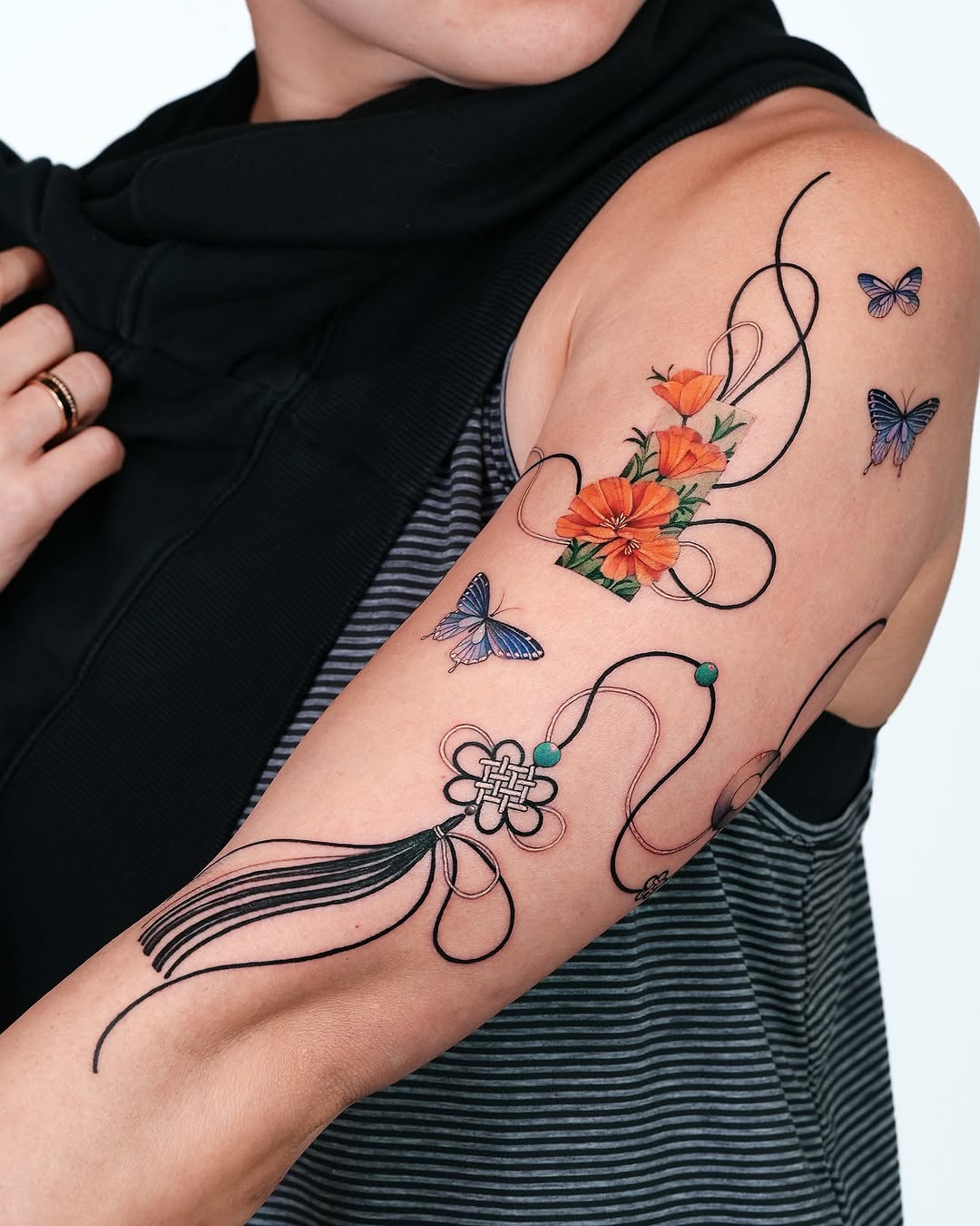 Vibrant floral and butterfly arm tattoo design