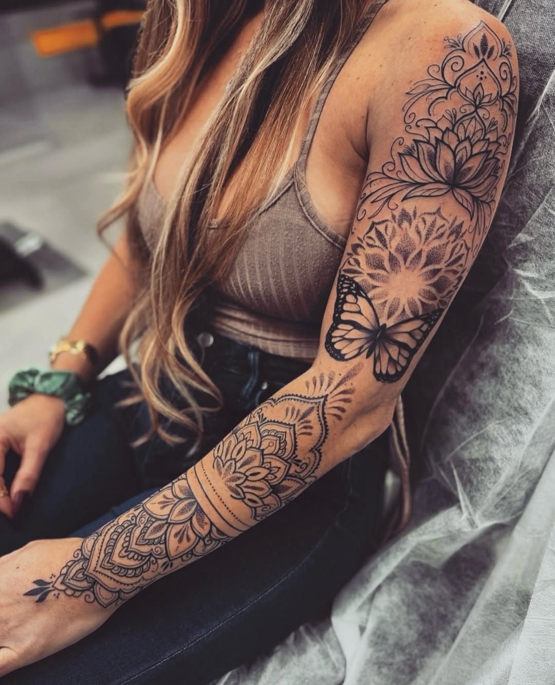Elegant arm tattoos with floral and butterfly motifs
