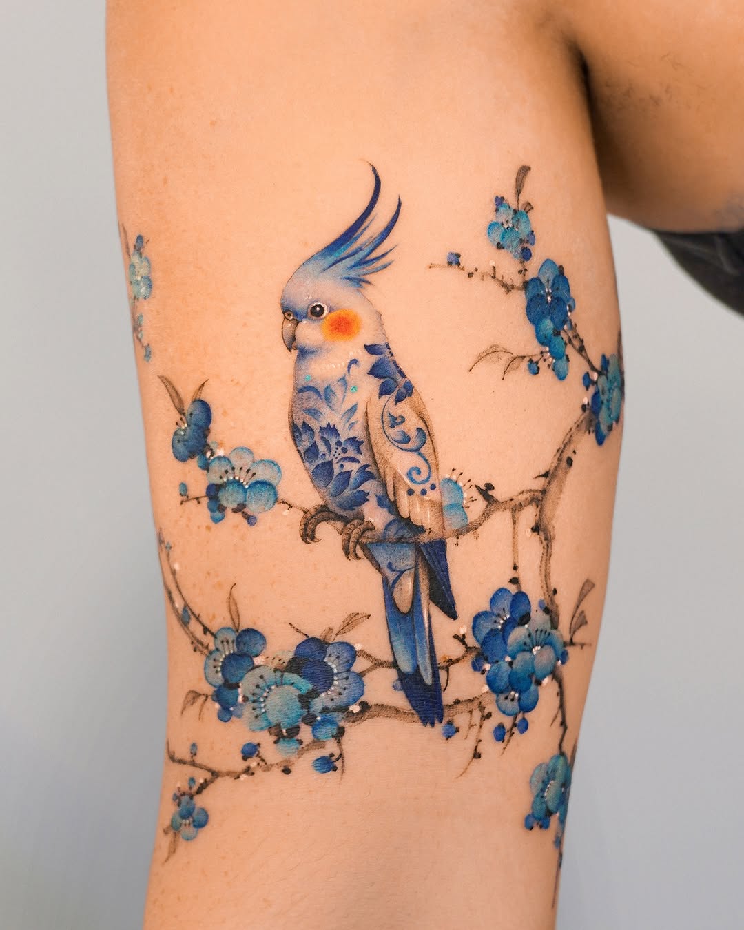 Vibrant Bird Tattoo with Floral Elements
