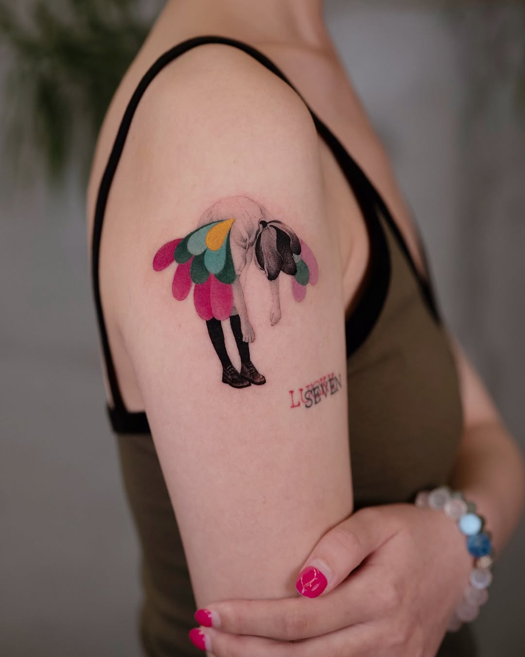 Whimsical arm tattoo with colorful wings