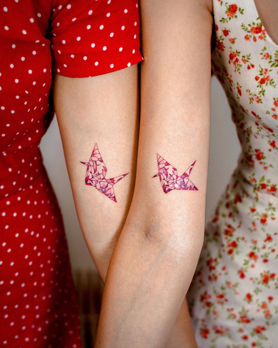 Elegant pink crane tattoos on feminine arms