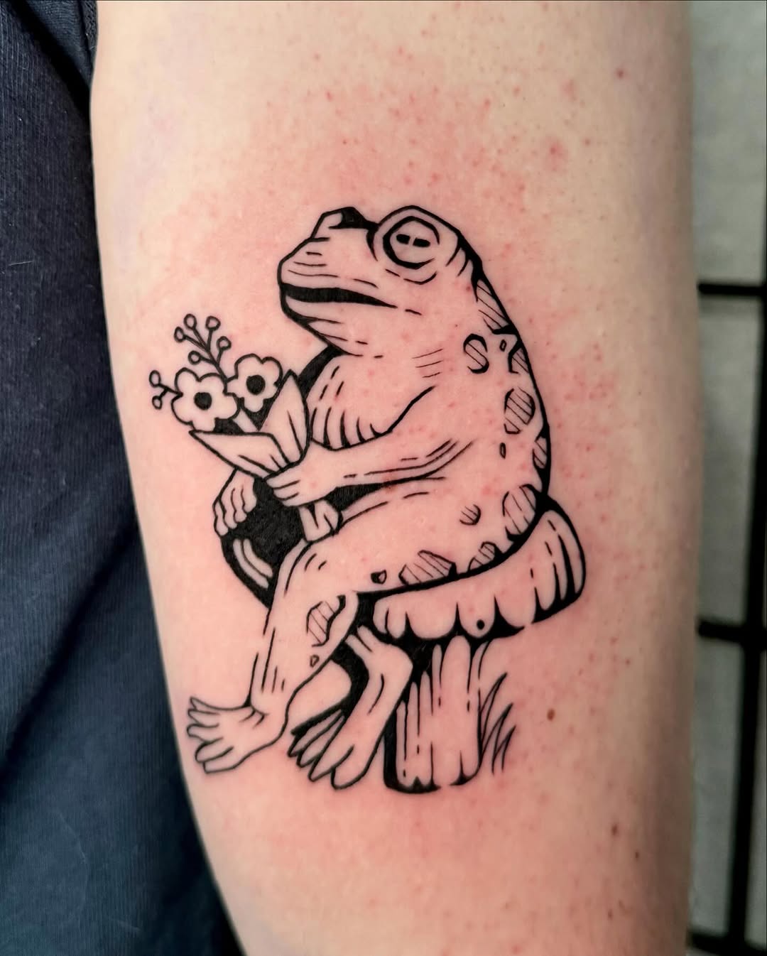 Charming frog tattoo with floral elements