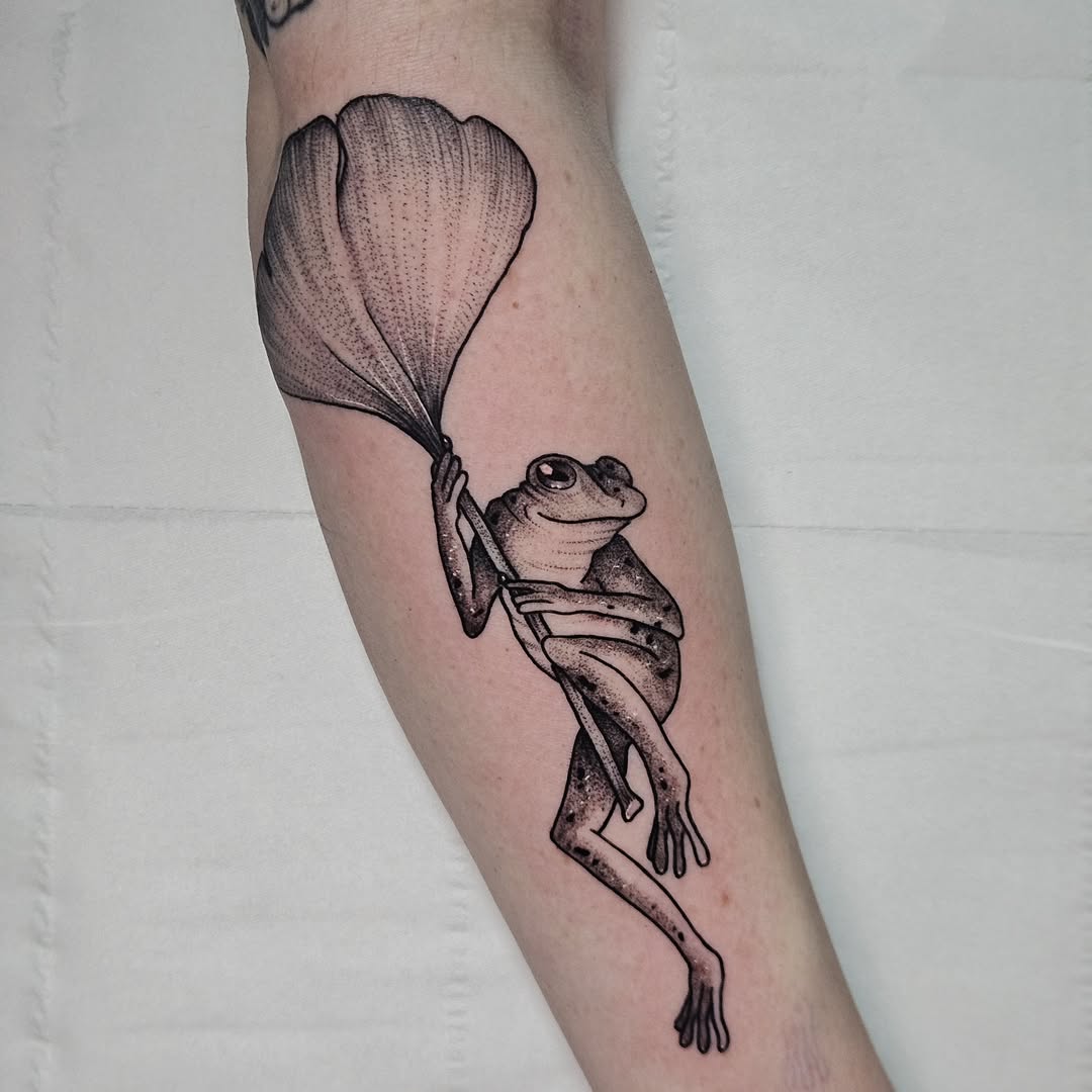 Unique frog tattoo holding a leaf design
