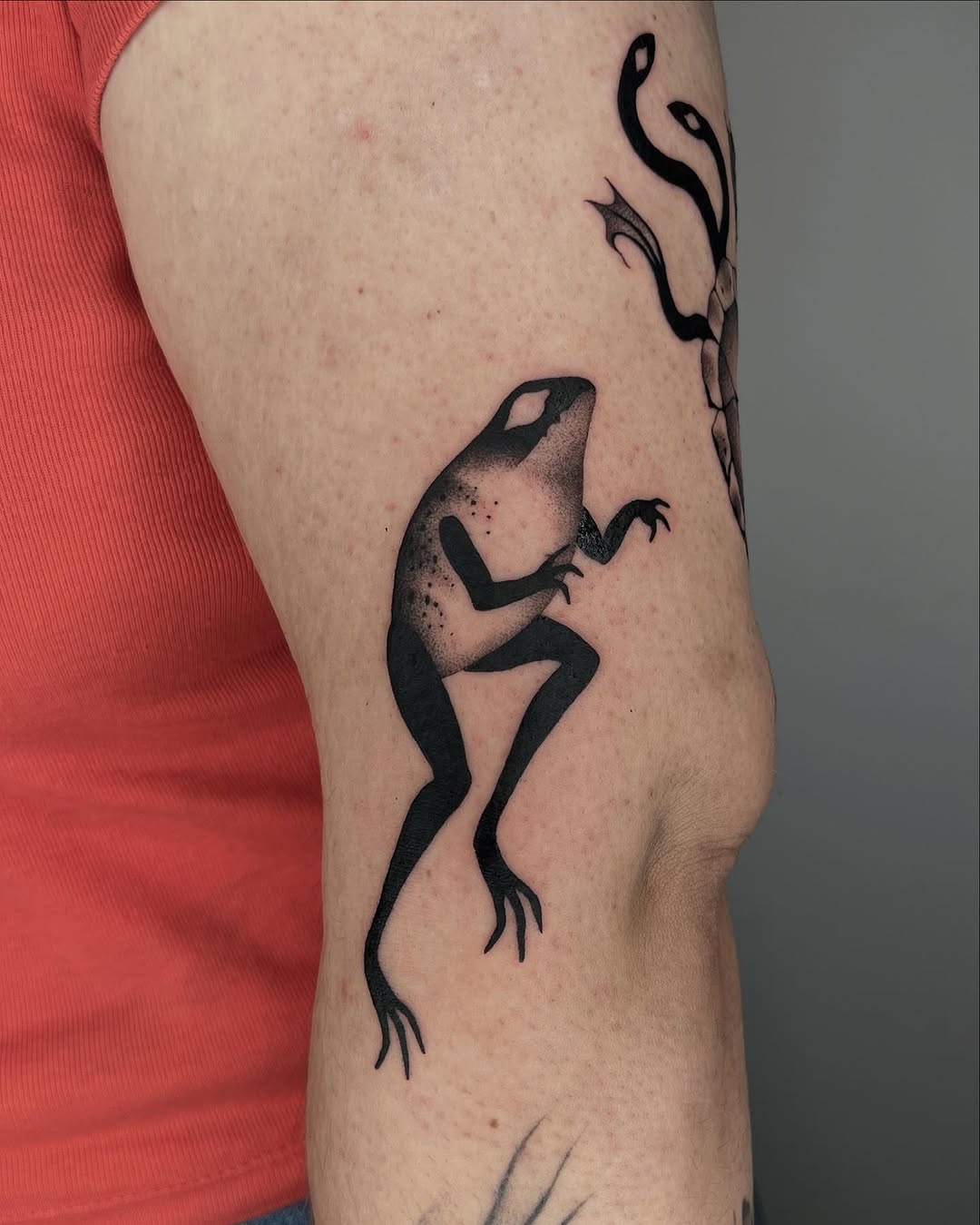 Stylish black ink frog tattoo on arm