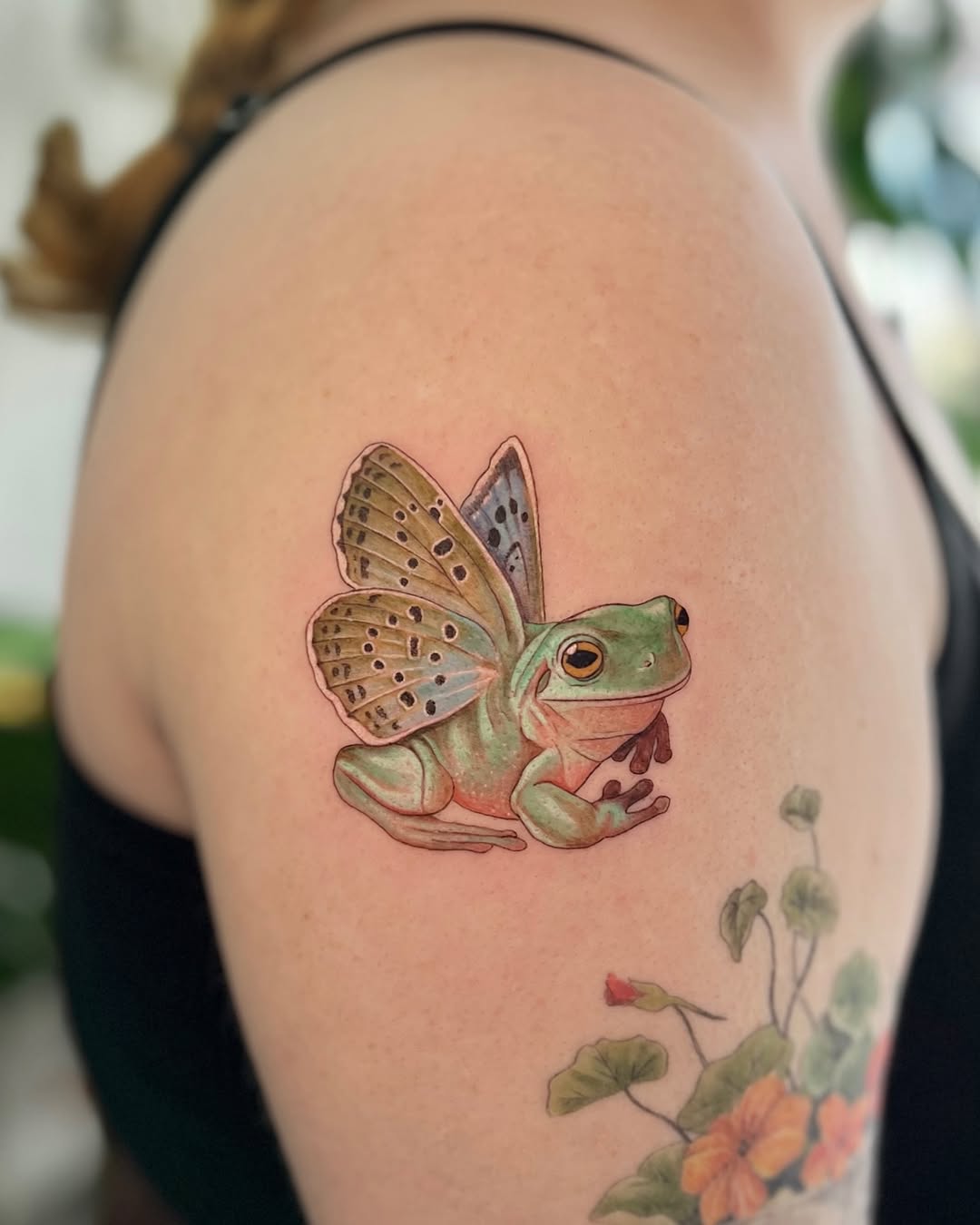 Whimsical frog tattoo with butterfly wings