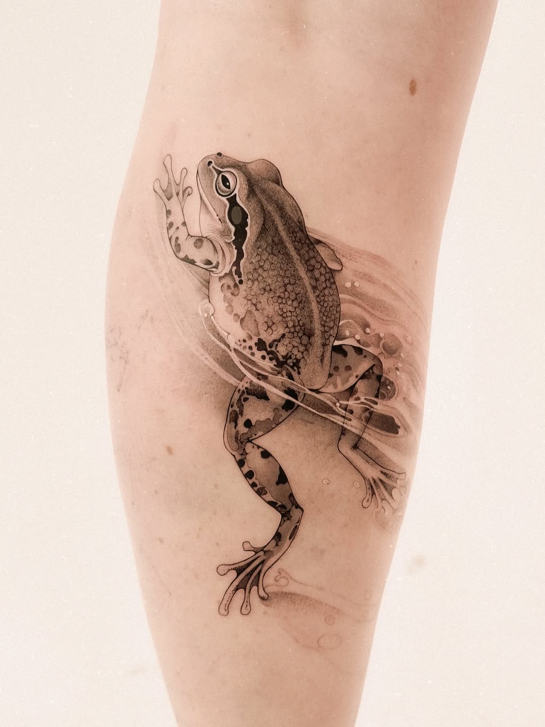 Graceful frog tattoo on smooth skin