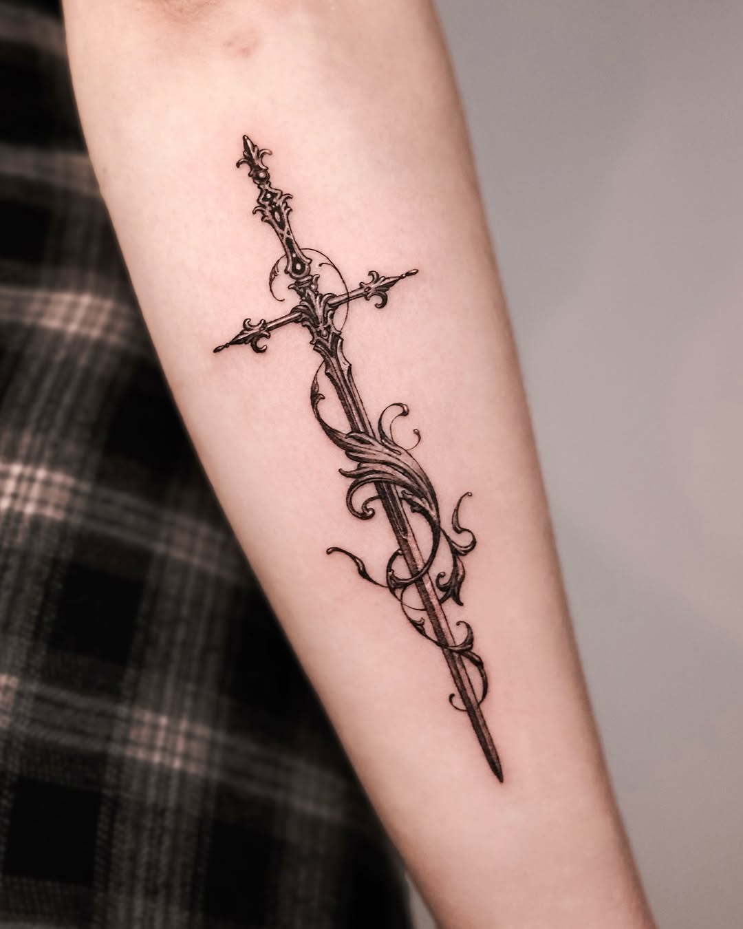 Elegant sword tattoo with floral details
