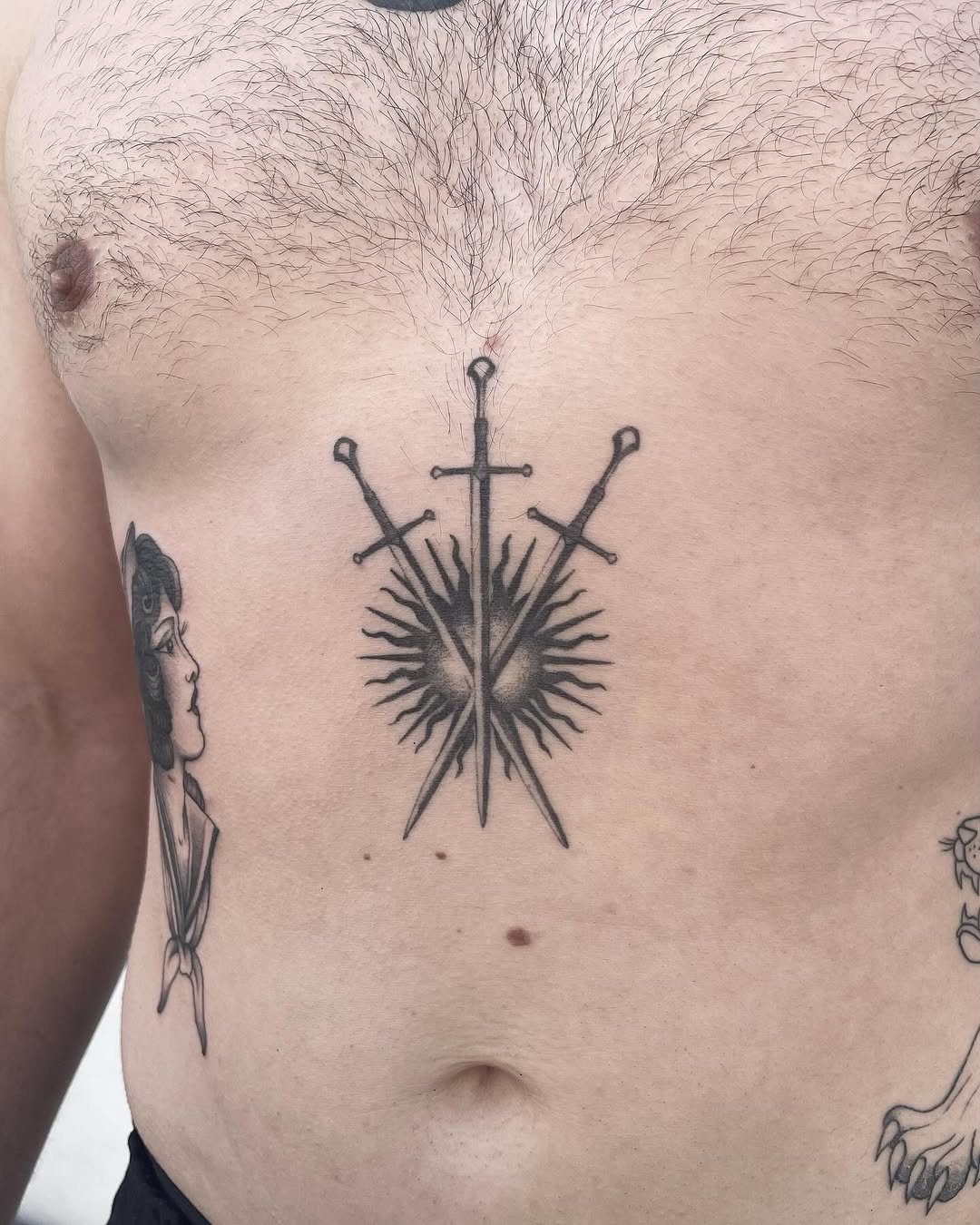 Bold chest tattoo featuring three striking swords