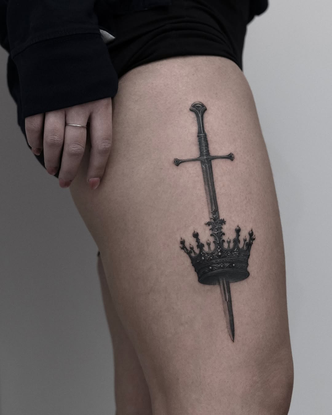 Bold sword and crown tattoo design