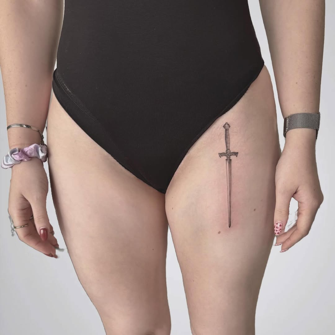 Elegant sword tattoo enhances thigh aesthetics