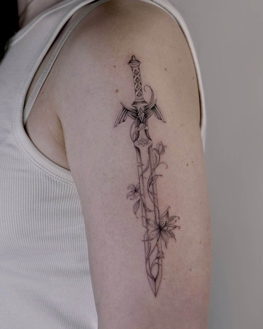 Stunning sword tattoo with floral accents