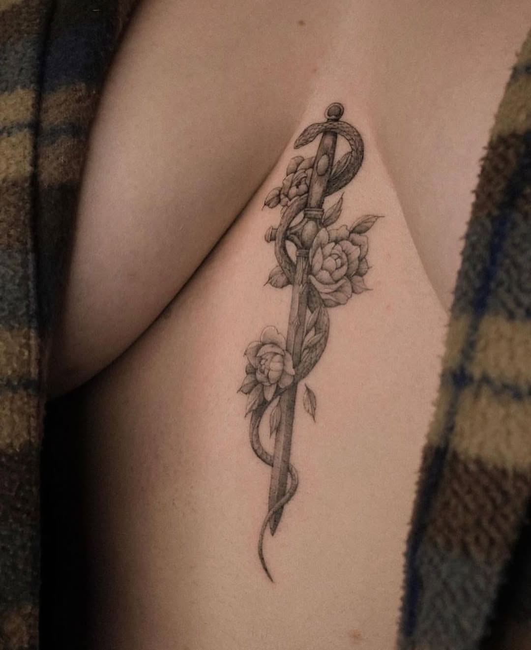 Elegant sword tattoo entwined with roses
