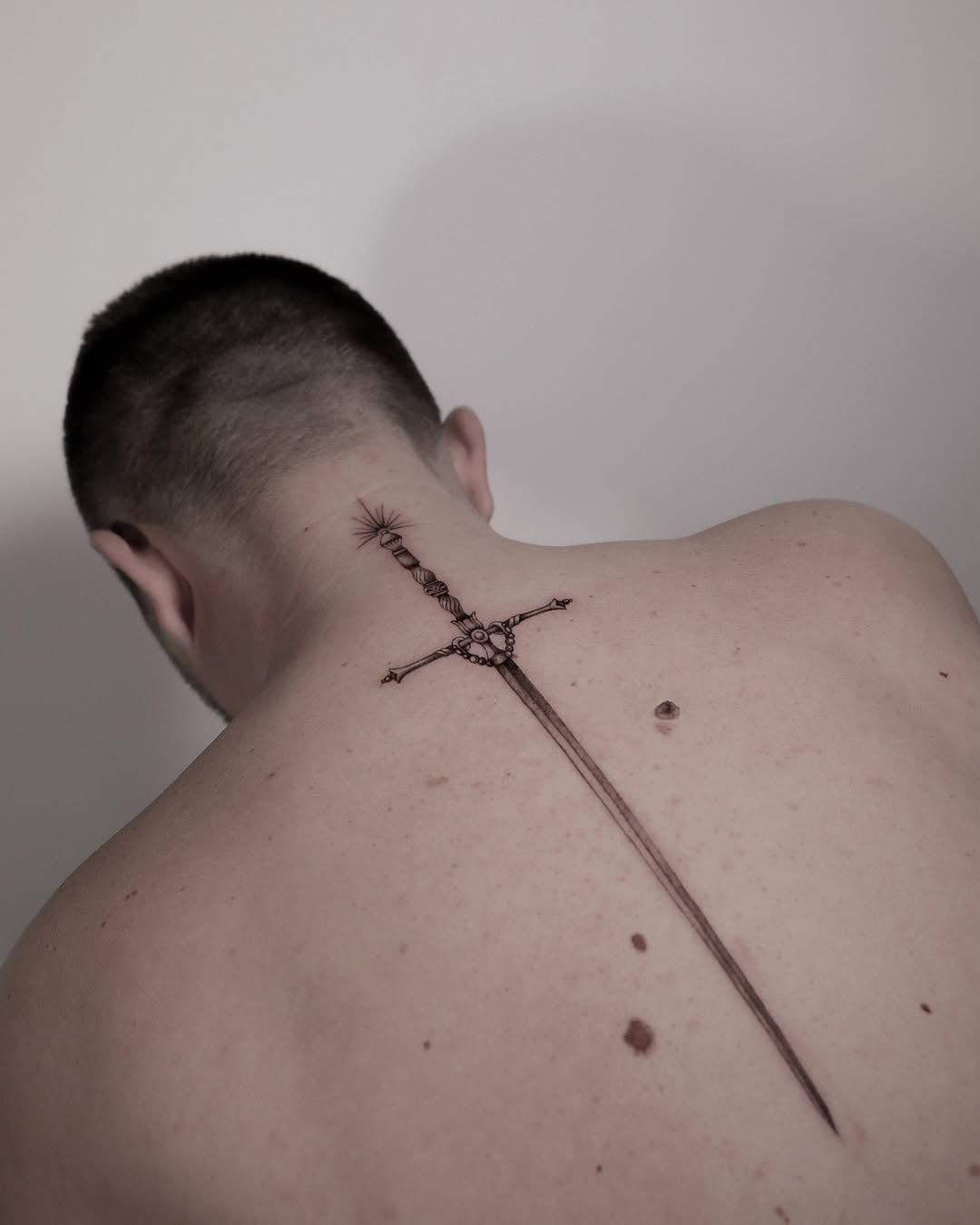 Intricate sword tattoo gracing the back.