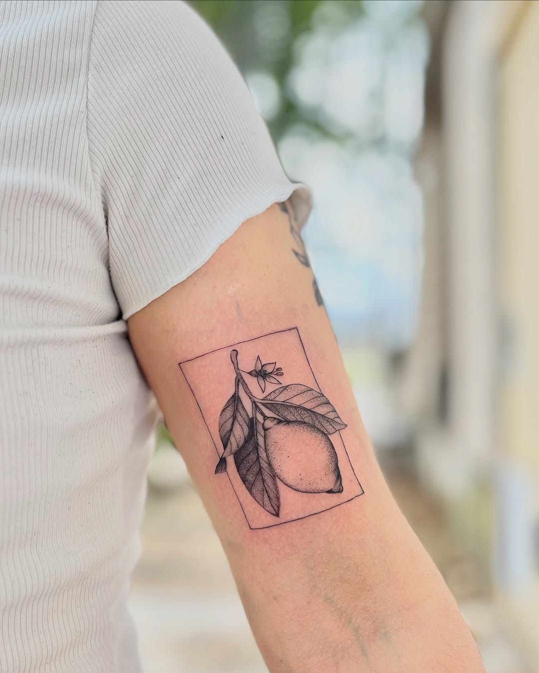 Minimalist lemon tattoo with delicate floral accents