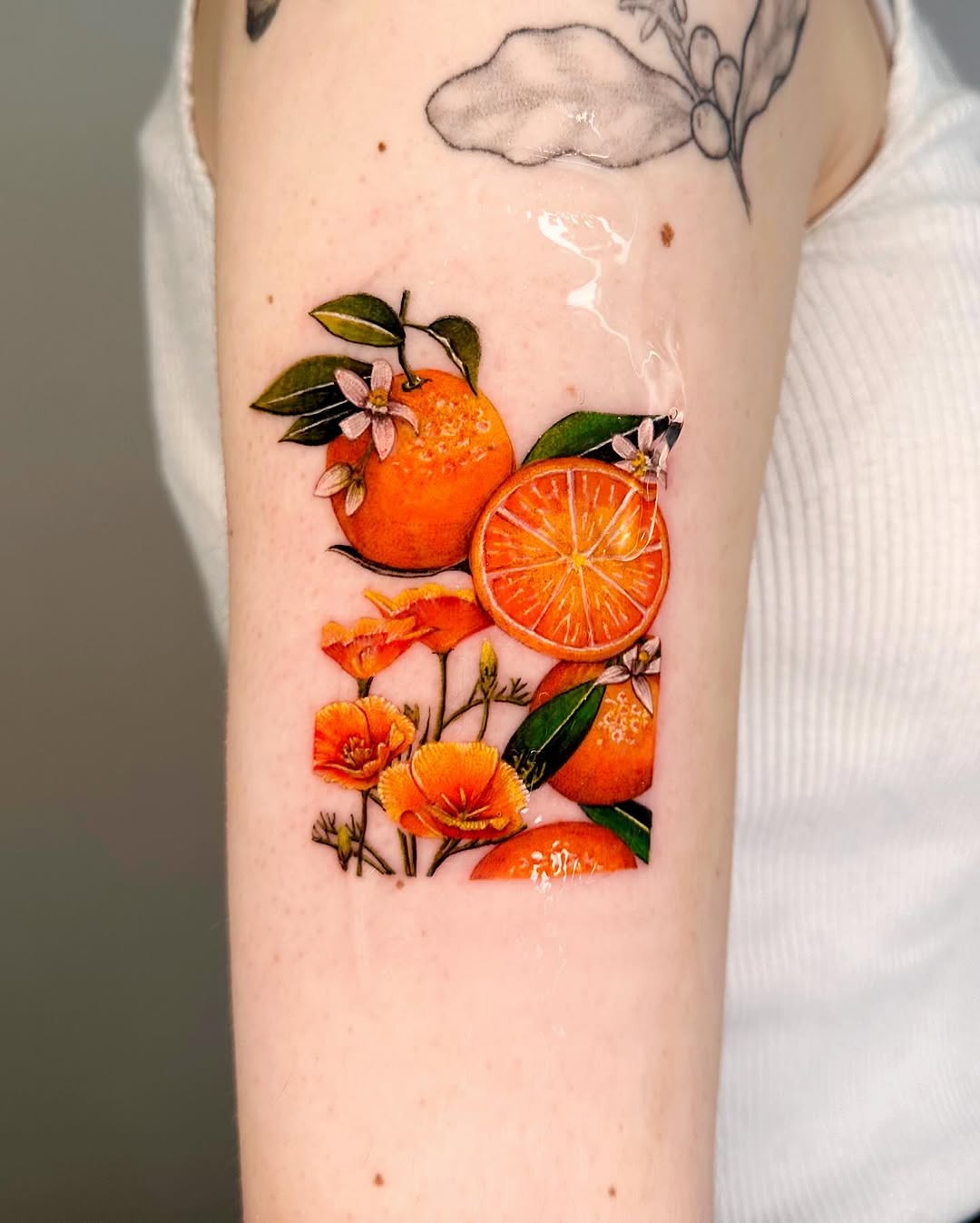 Vibrant lemon tattoo with floral elements