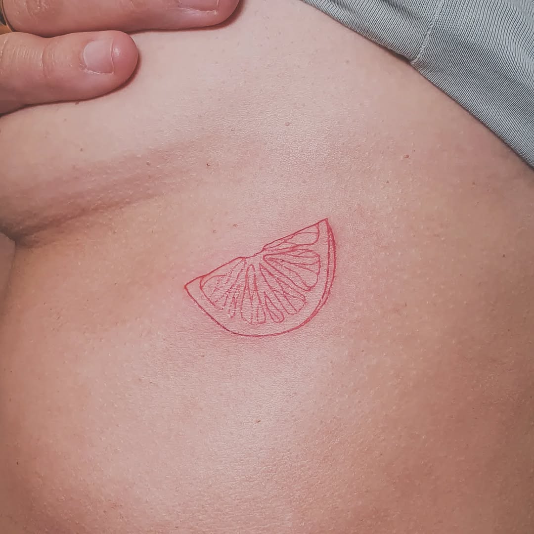 Playful Red Lemon Slice Tattoo Design