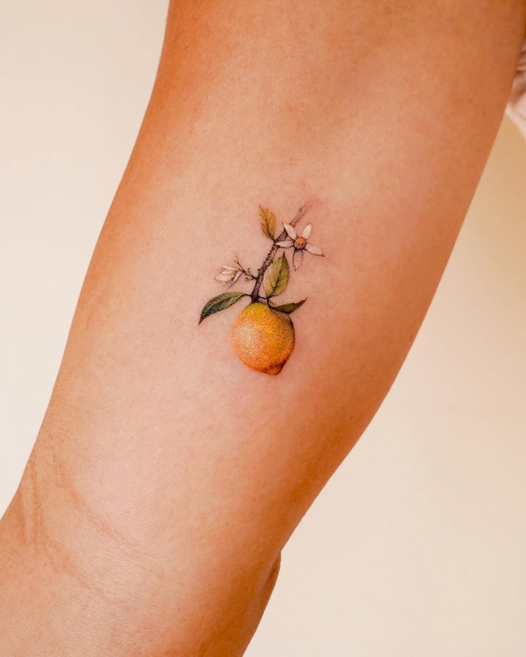 Charming lemon tattoo with floral accents