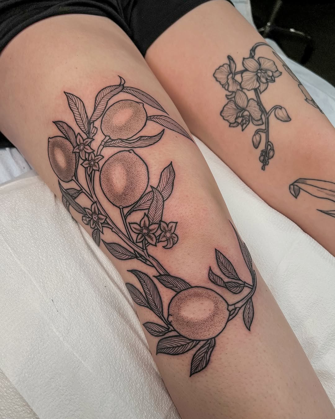 Elegant lemon tattoo design with floral elements