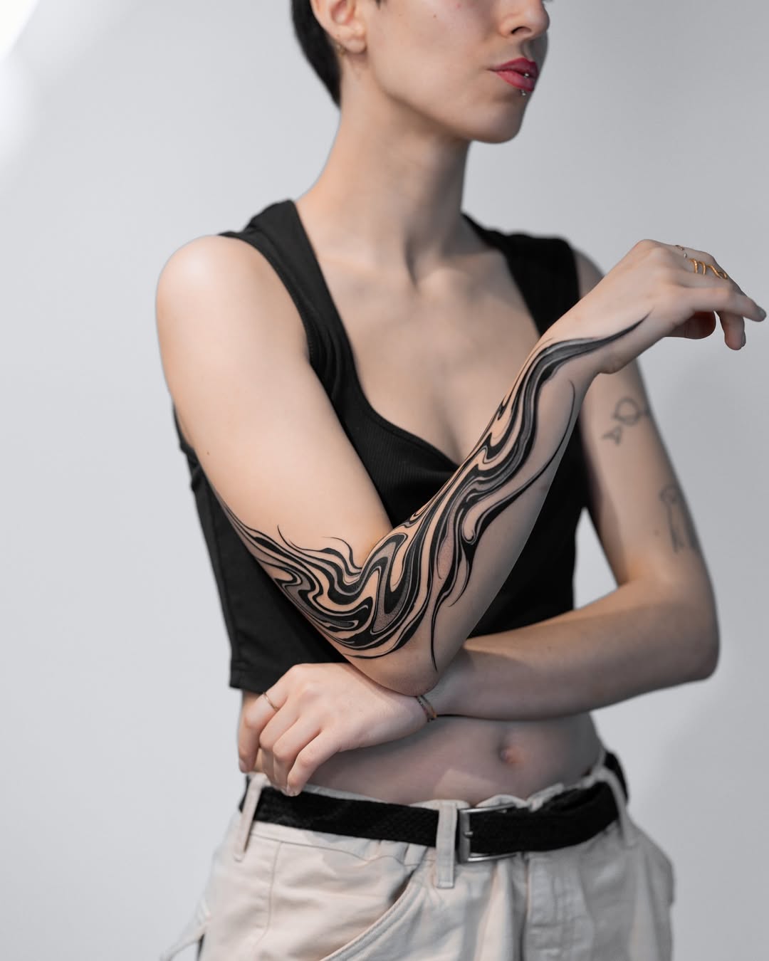 Fluid black ink waves on the forearm