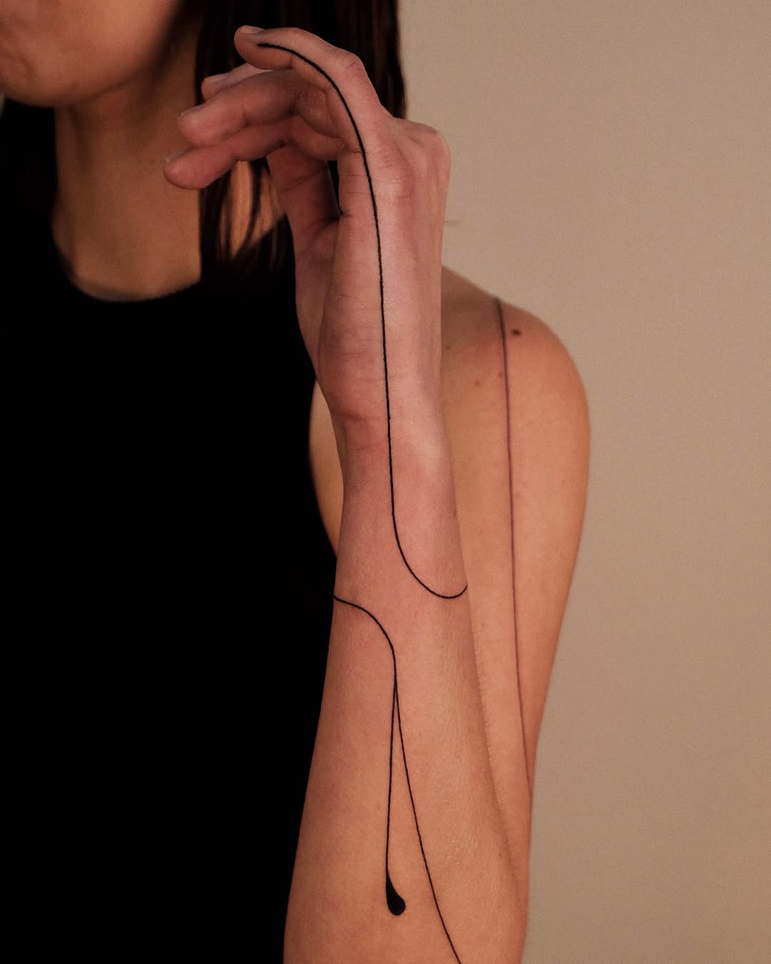 Elegant minimalist line art tattoo on arm