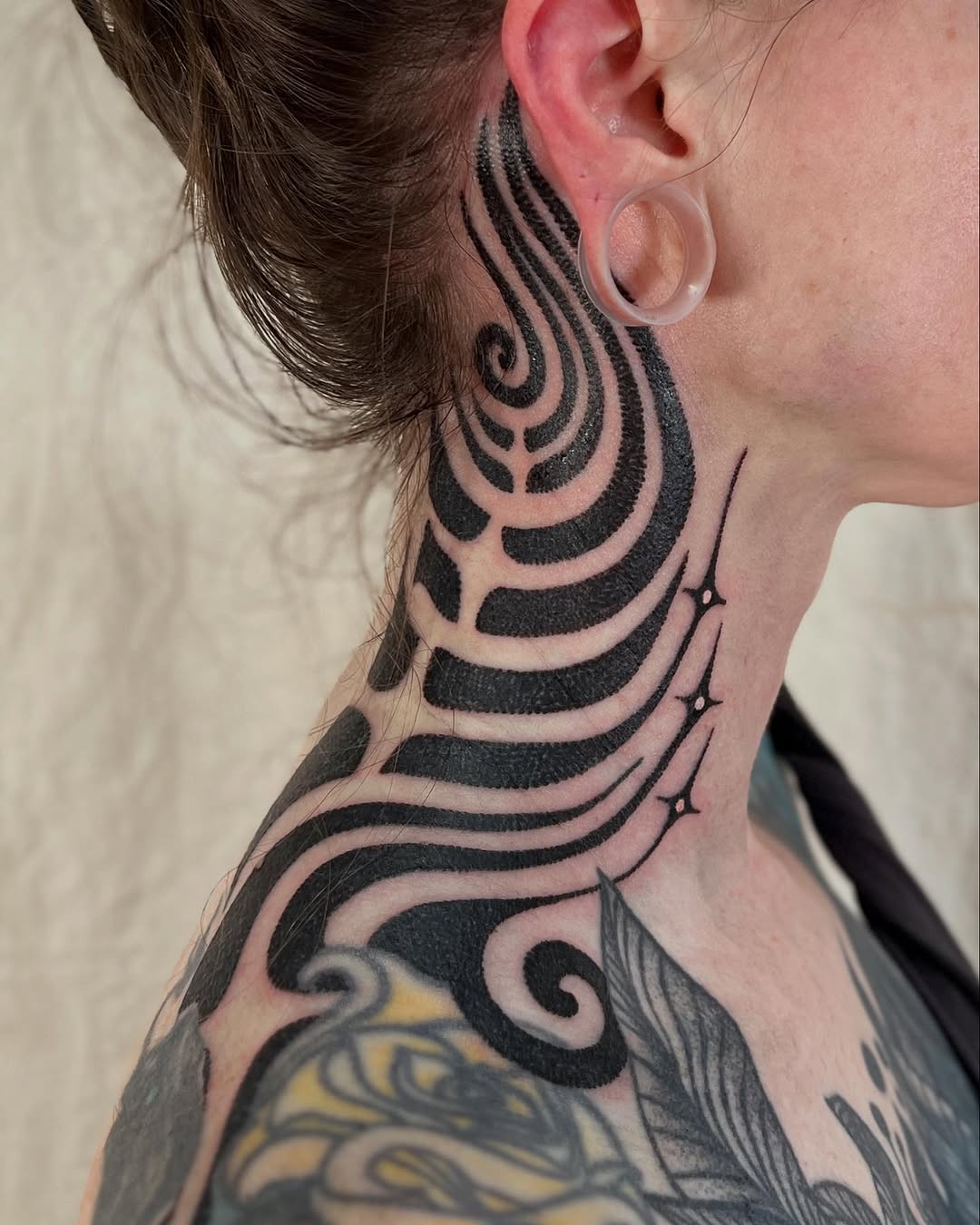 Flowing lines create dynamic neck tattoo design
