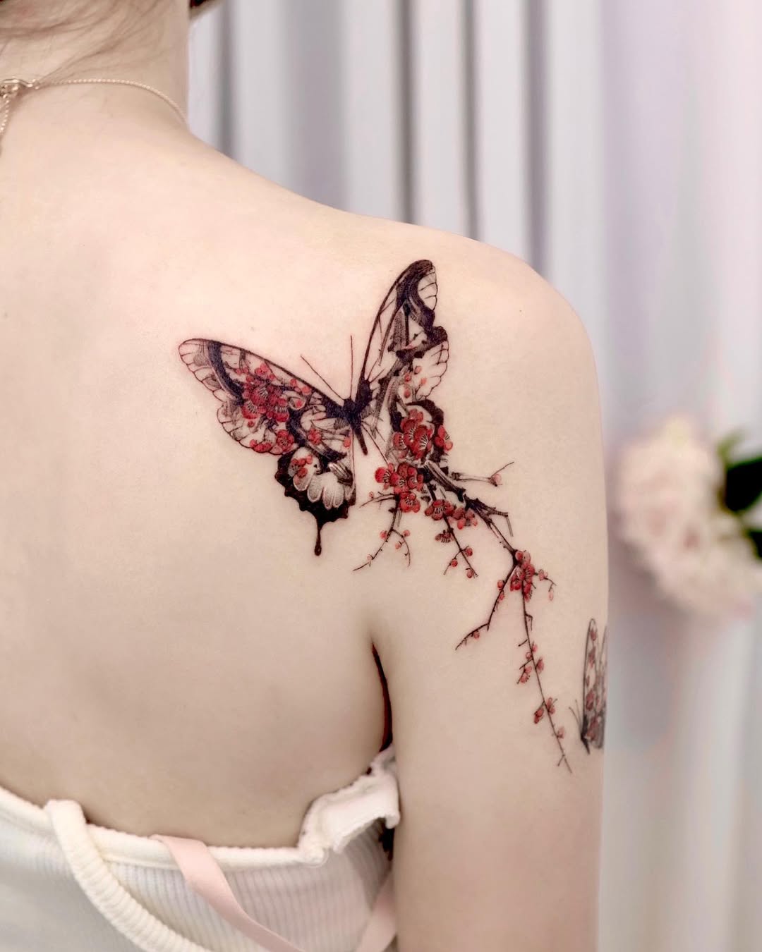 Elegant butterfly tattoo with floral elements