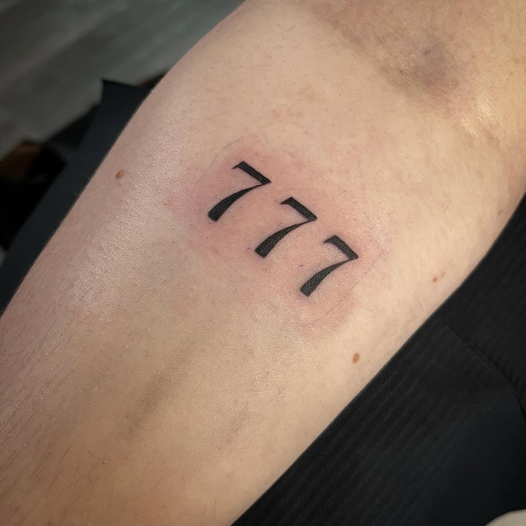 Minimalist 777 tattoo on forearm