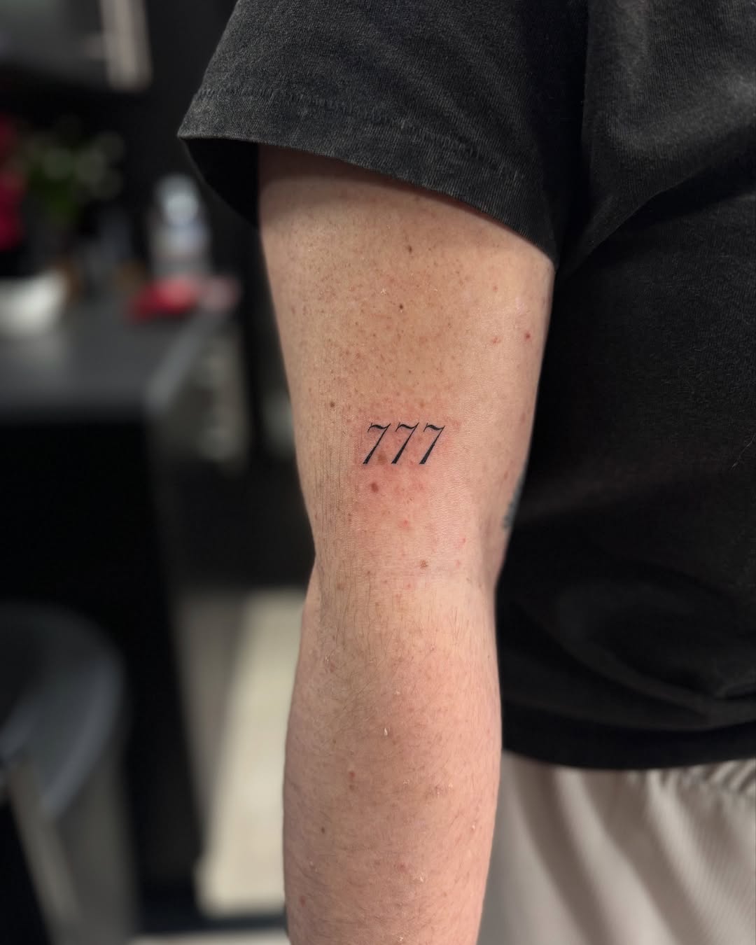 Minimalistic 777 tattoo on the arm