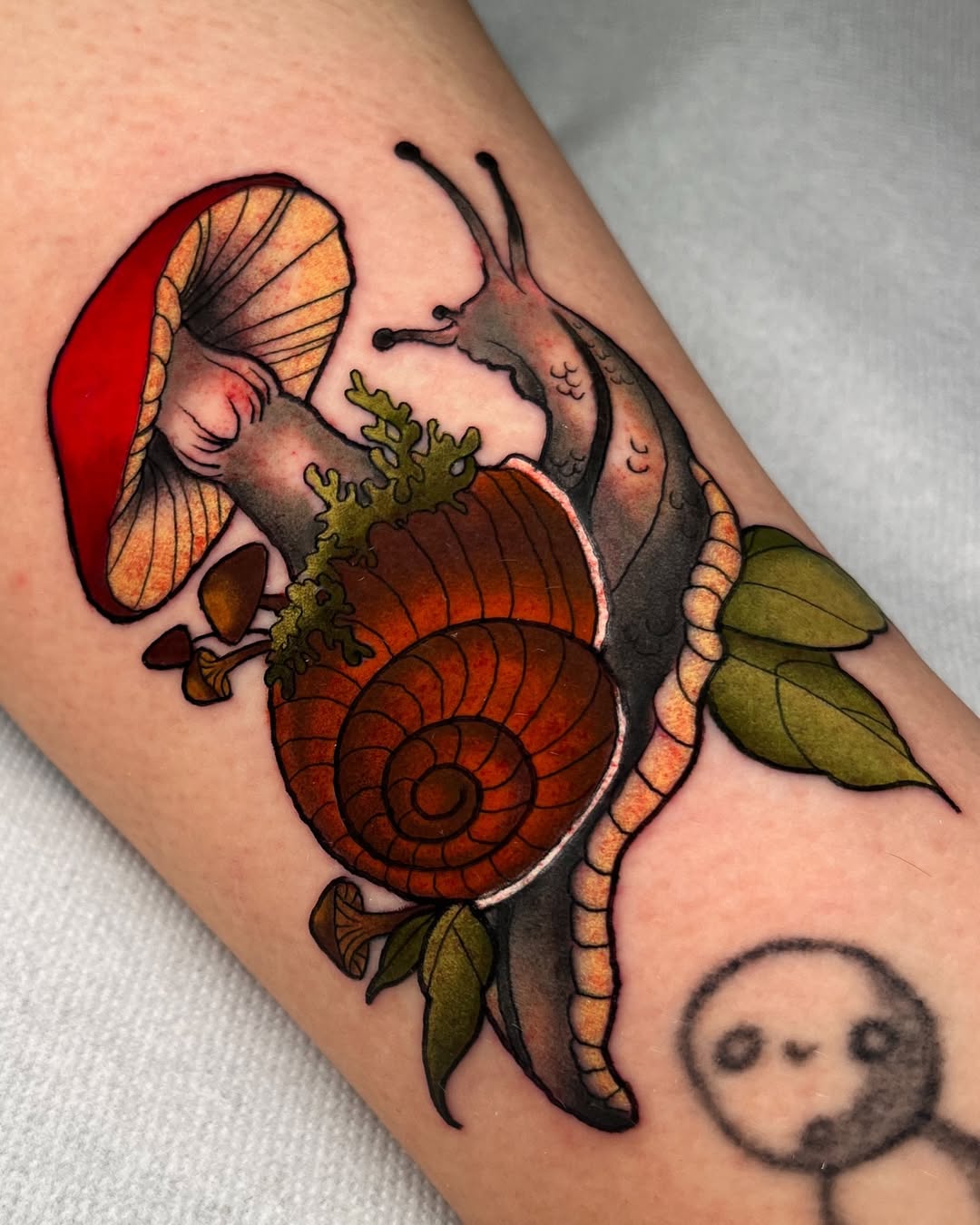 Whimsical mushroom and snail tattoo design