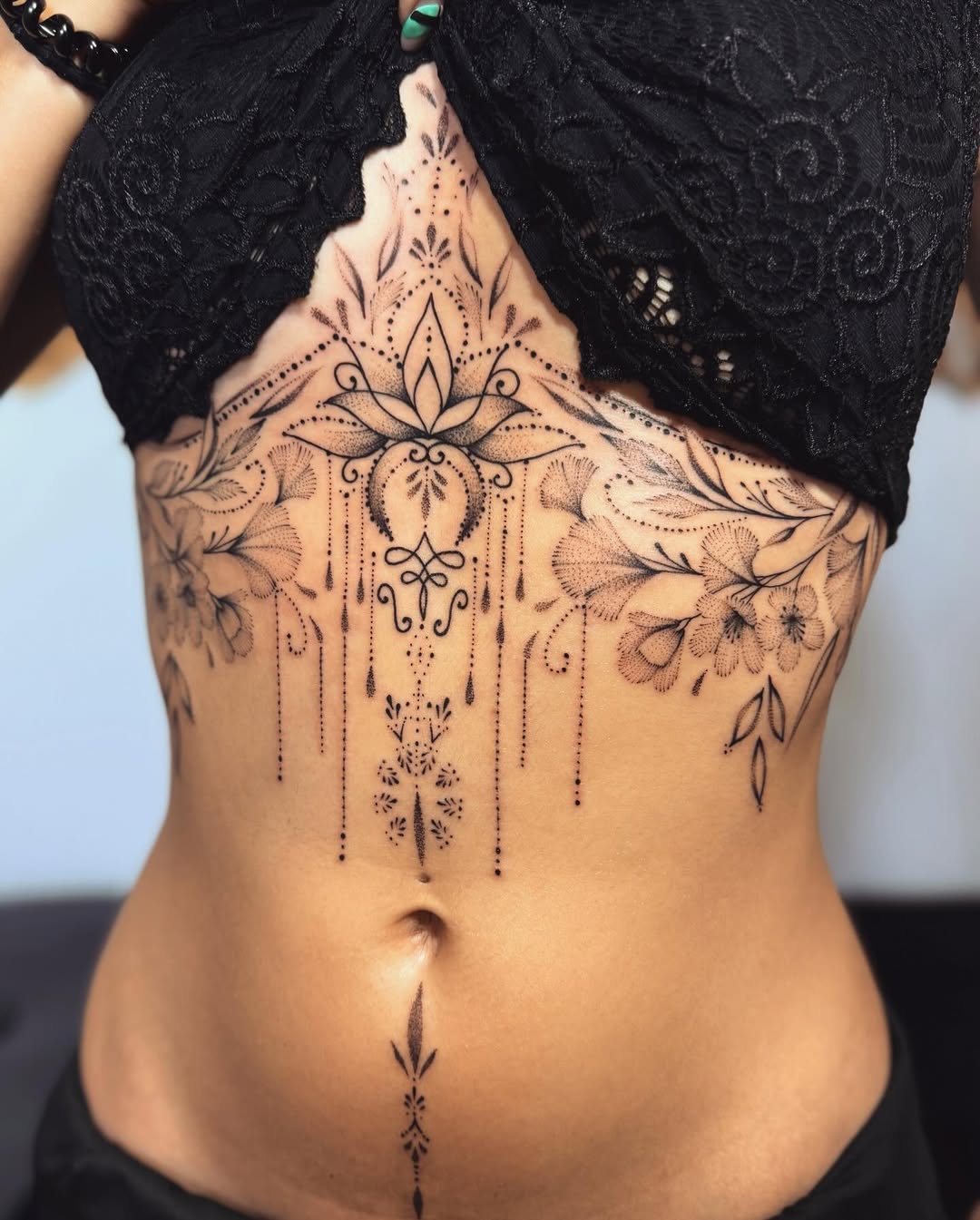 Intricate floral mandala tattoo on the belly