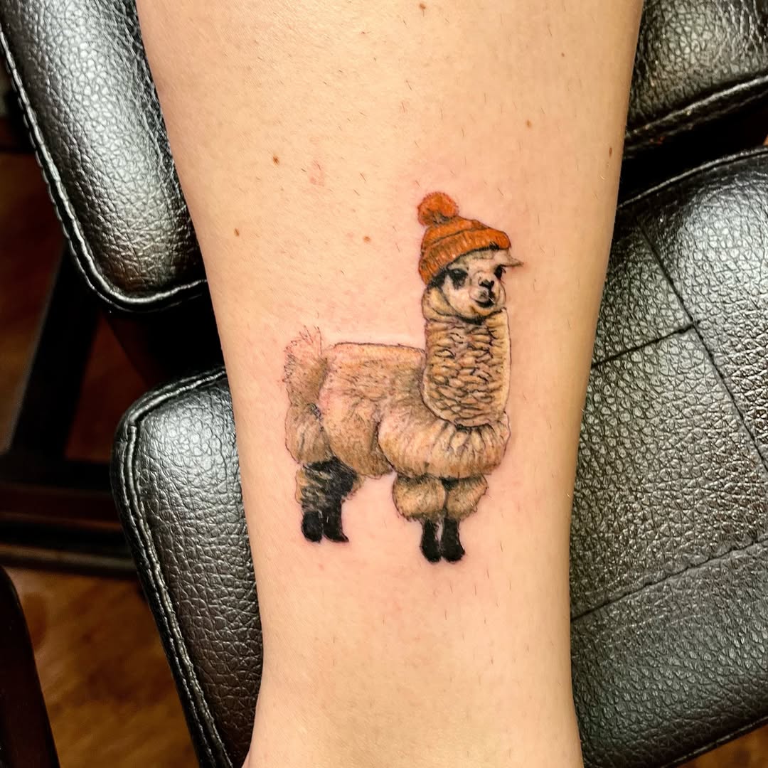 Charming llama tattoo with a winter hat