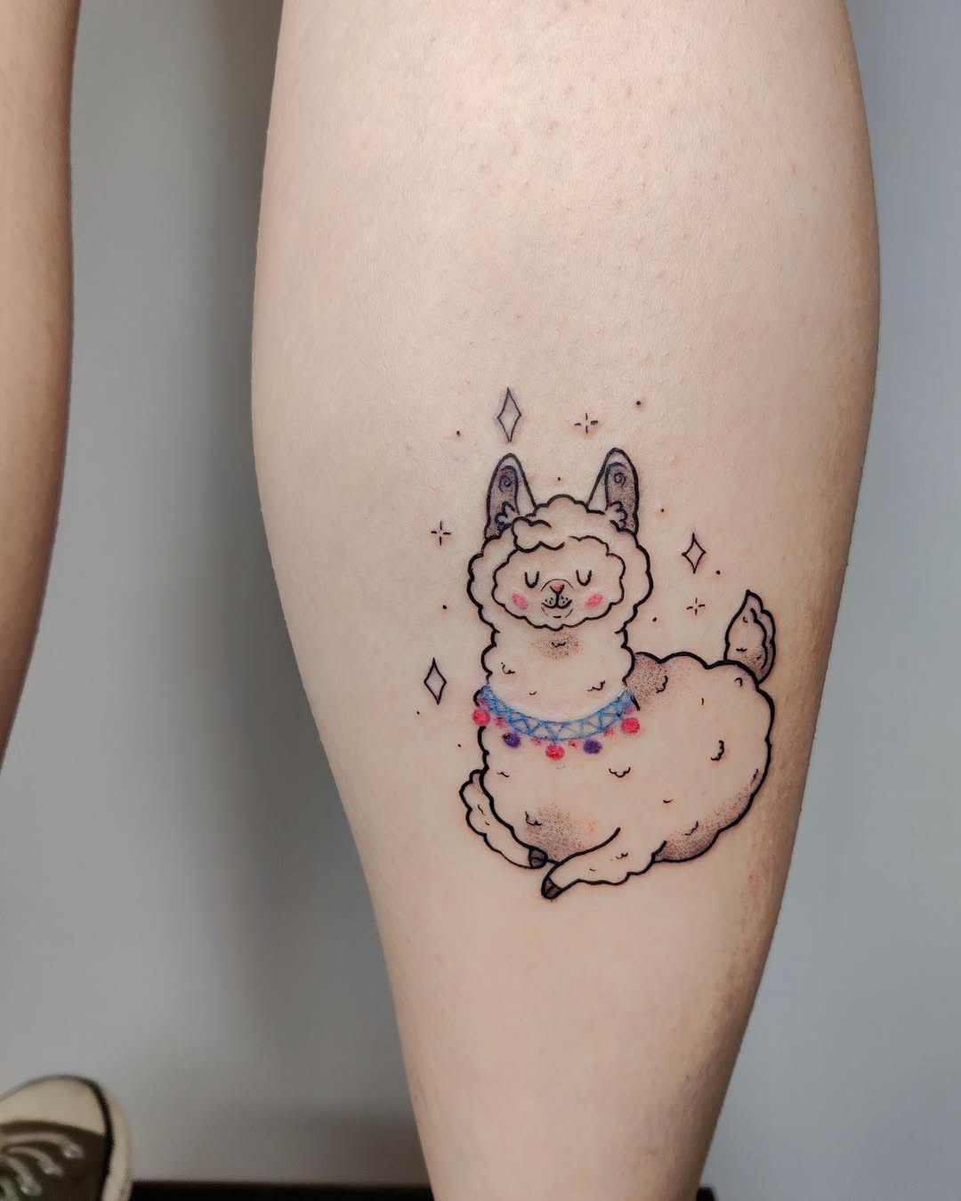 Charming colorful llama tattoo on calf