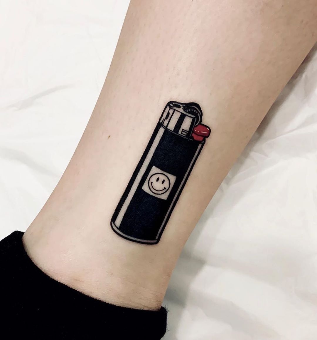 Quirky lighter tattoo with a smiley face