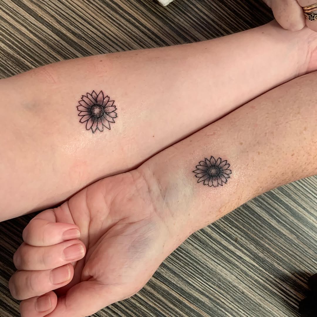 Charming sunflowers on mother and daughter arms