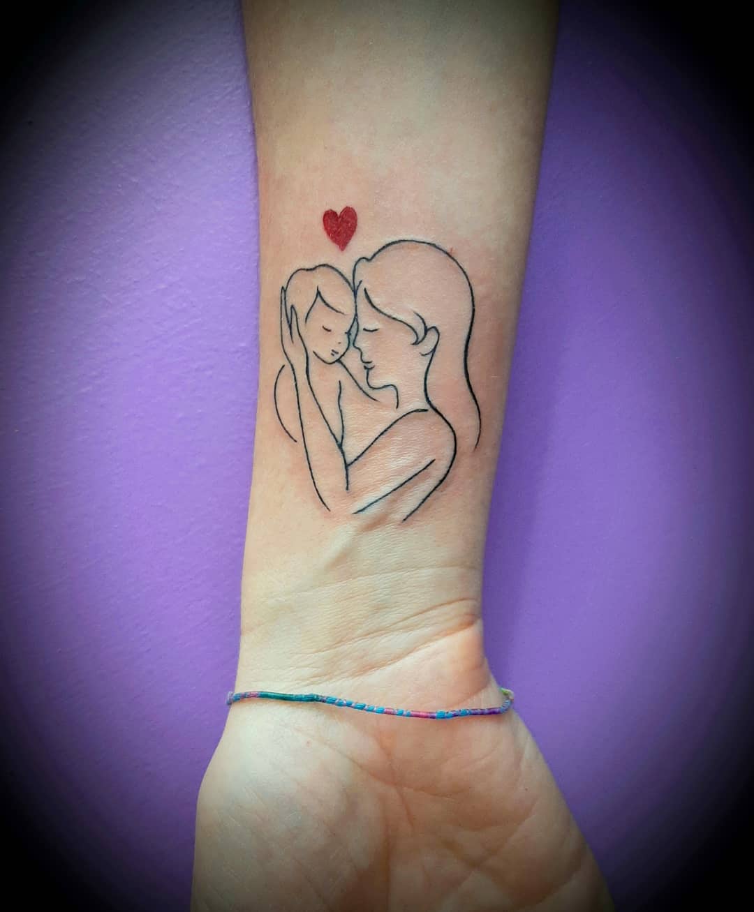 Tender mother-child tattoo with a heart.