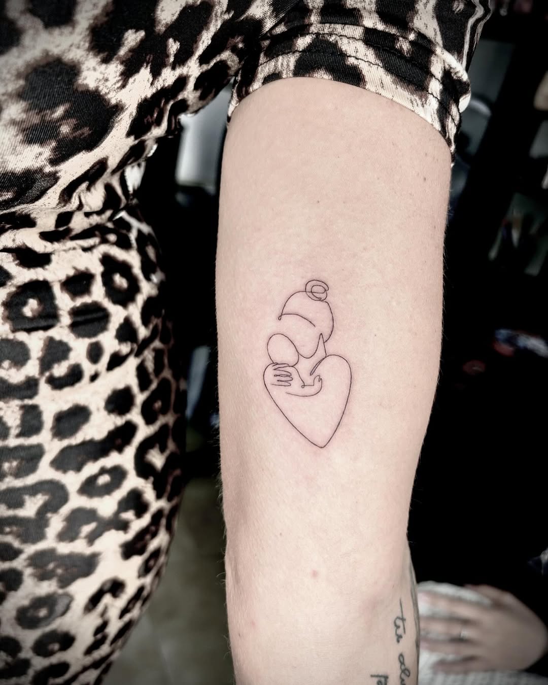 Delicate mother-and-child line art tattoo