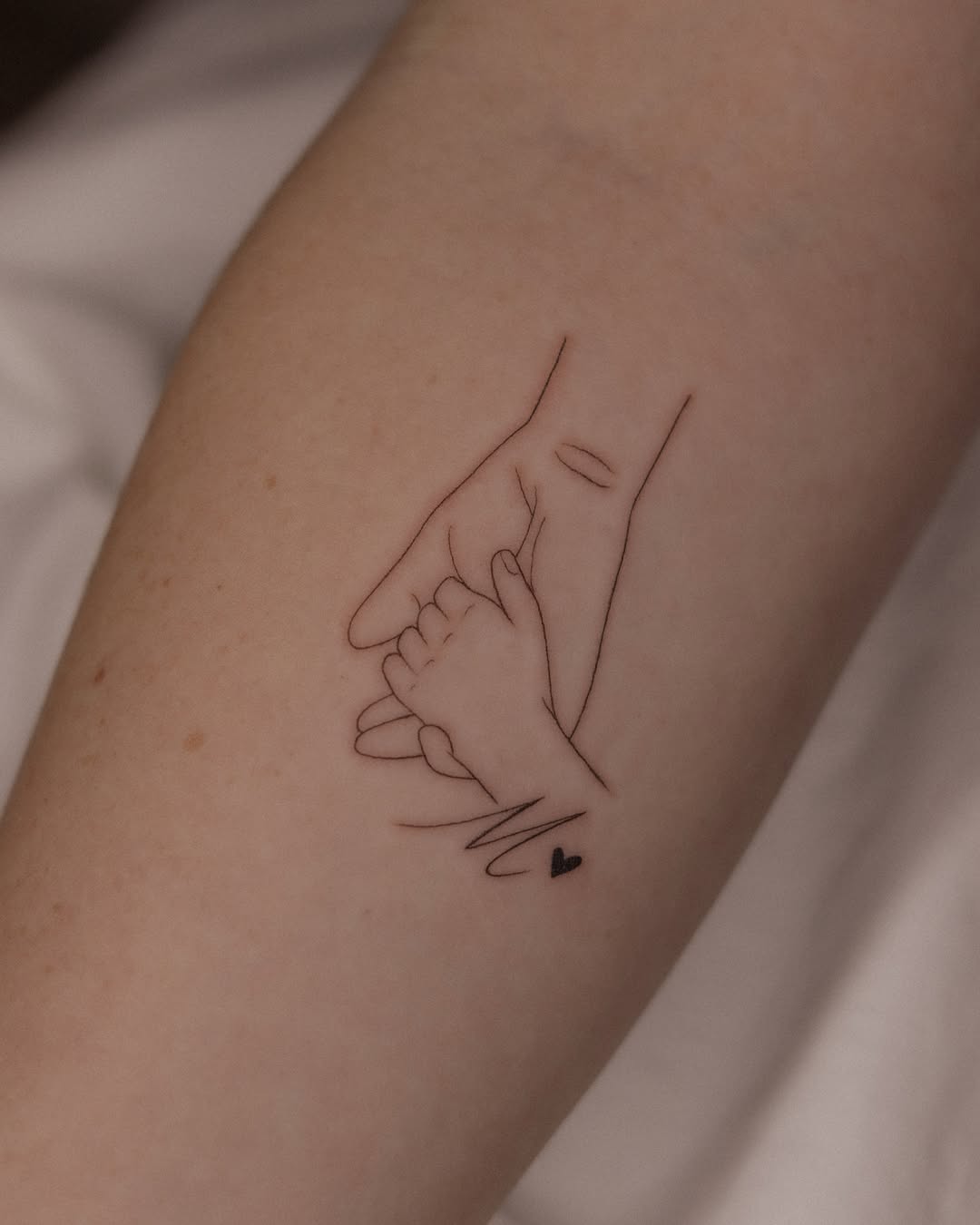 Elegant tattoo of a mother and child’s hands